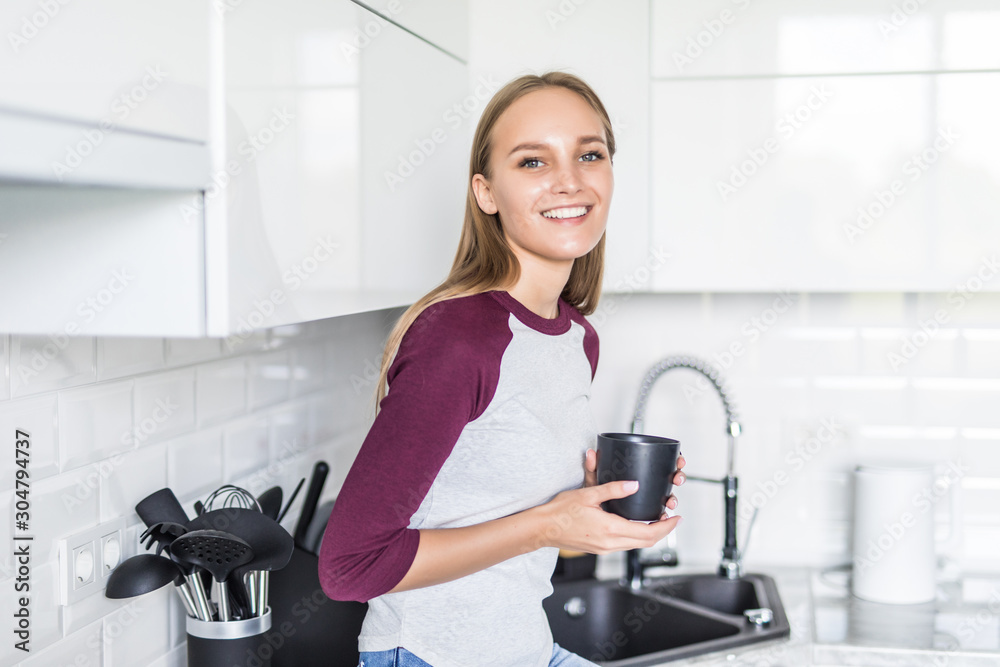 Young pretty woman sitting on kitchen counter at home Young pretty woman sitting on kitchen counter at home