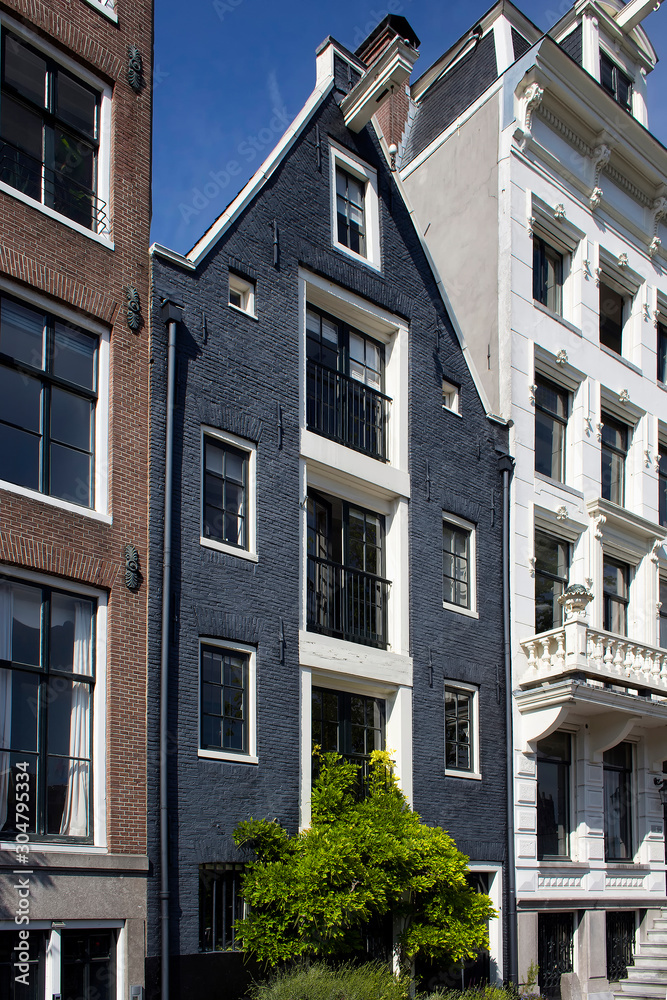 Fototapeta premium Close up view of historical, traditional and typical buildings showing Dutch architectural style in Amsterdam. It is a sunny summer day.