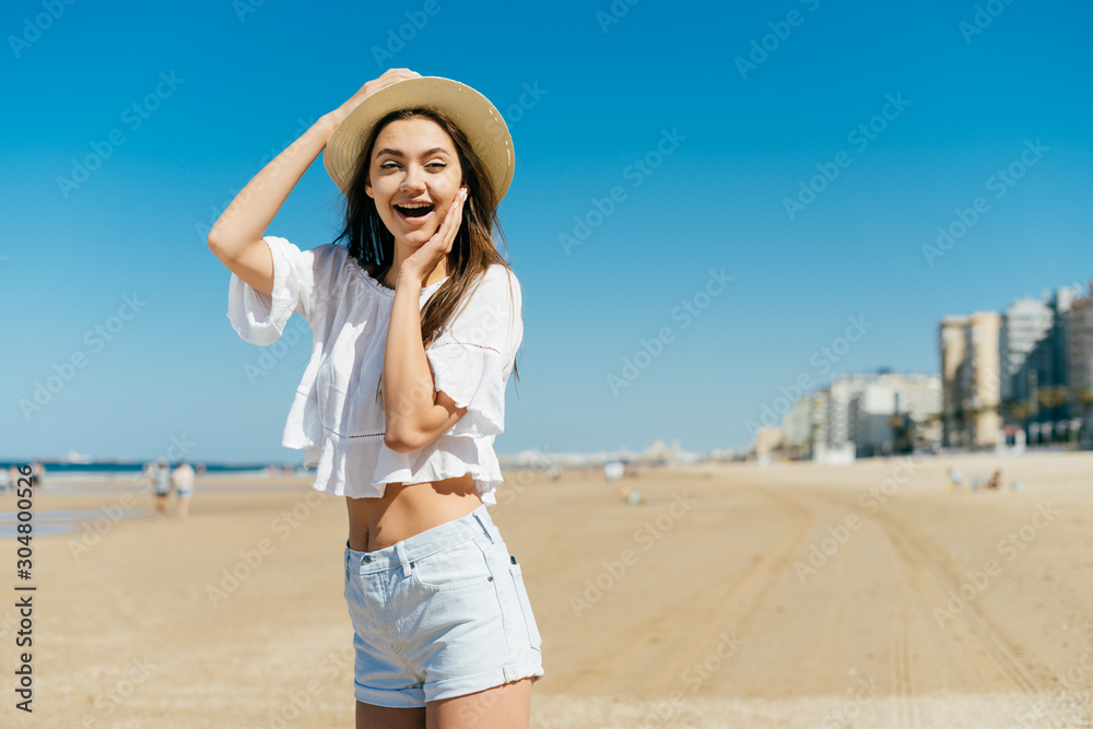 the girl with joyfully surprised emotion opened her mouth and holds her cheek. beach the girl with joyfully surprised emotion opened her mouth and holds her cheek. beach