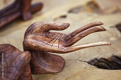 Close up of hands Wooden figurine of a female hand. Image for beauty and fashion concept.