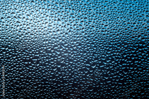 drops of rain water water on a blue glass surface