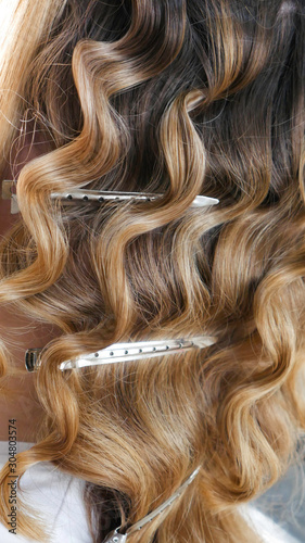 Silver hairdressers clips in curly hair.