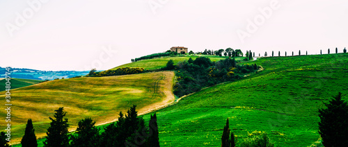 View of a autumn day in the Italian rural landscape. Unique tuscany landscape in fall time. Wave hills  cypresses trees and cloudy sky. Vintage tone filter effect.
