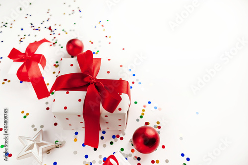 Christmas card with gift box and toys on White background. Top view with place for your congratulations.