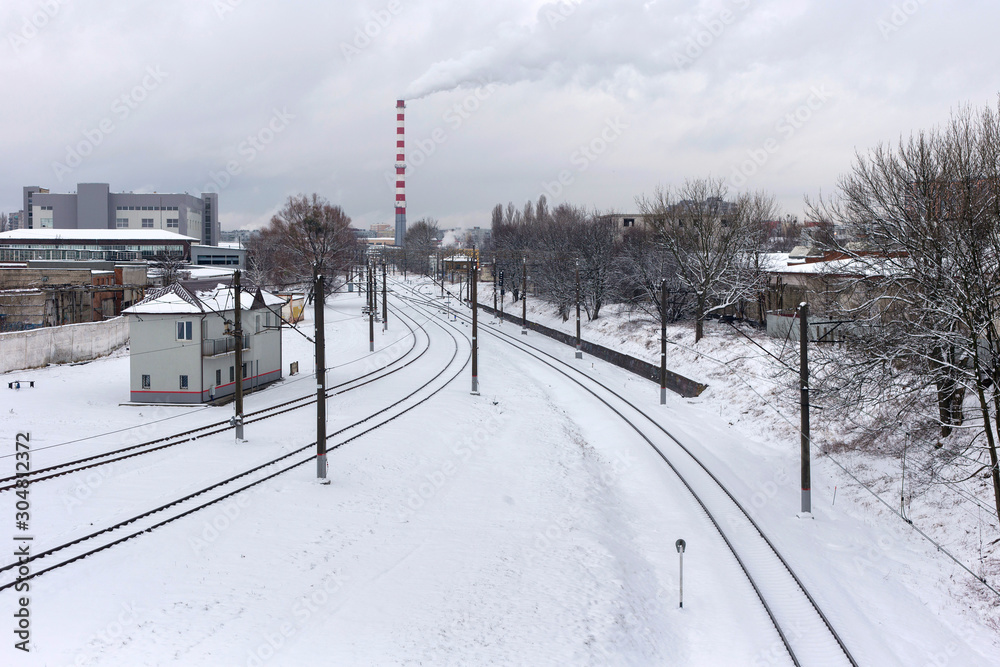 View of the snow-covered industrial city landscape with railway tracks. Russia. View of the snow-covered industrial city landscape with railway tracks. Russia.