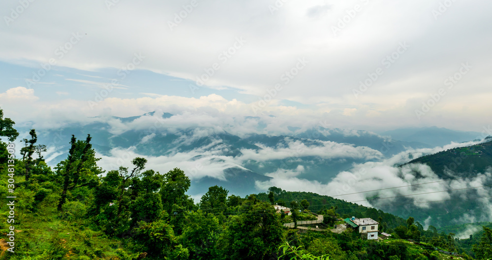 A beautiful view of the low monsoon clouds over the mountain ranges at sunset, Mussoorie, Uttarakhand, India