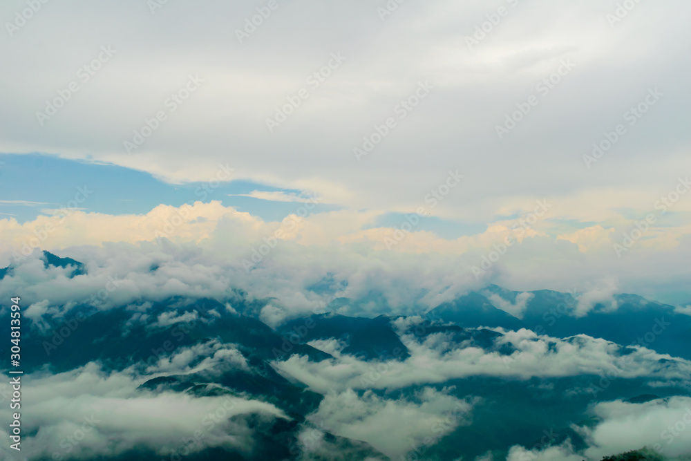 A beautiful view of the low monsoon clouds over the mountain ranges at sunset, Mussoorie, Uttarakhand, India
