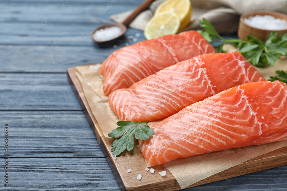 Fresh raw salmon with parsley on blue wooden table. Fish delicacy Fresh raw salmon with parsley on blue wooden table. Fish delicacy