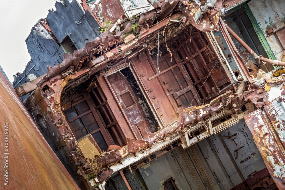 Huge rusty pieces of decommissioned marine ship that was cut and left on the shore.