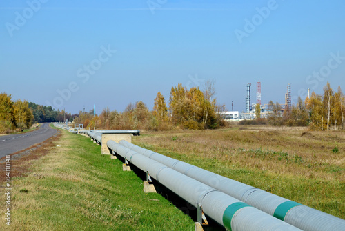 Natural Gas Pipelines network. Gas Processing Plant in Belarus, Rechitsa, Gomel region. Pipe and industrial refinery towers of the natural gas factory on the background blue sky. Oil equipment photo