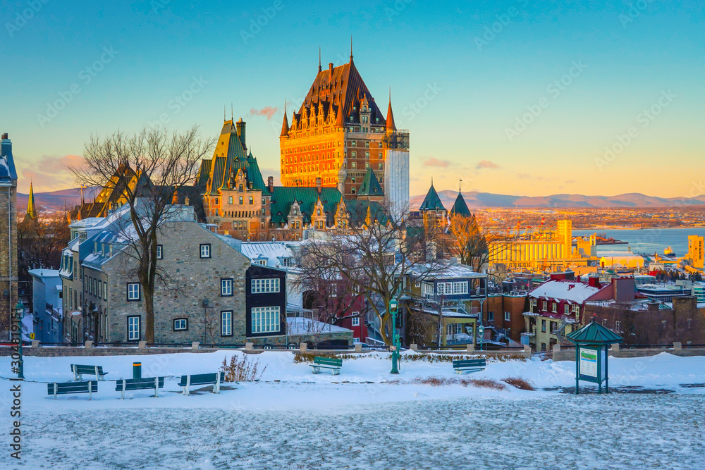 Naklejka premium Widok na panoramę miasta Quebec z Chateau Frontenac na tle rzeki Świętego Wawrzyńca, wioski, gór i żywego nieba w tle o zmierzchu w zimie
