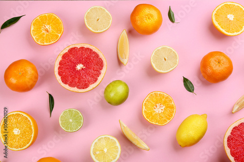 Flat lay composition with tangerines and different citrus fruits on pink background