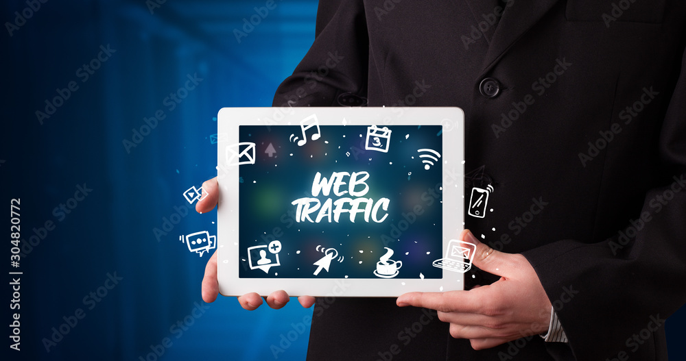 Young business person working on tablet and shows the inscription: WEB TRAFFIC Young business person working on tablet and shows the inscription: WEB TRAFFIC