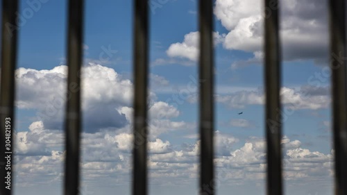 A timelapse of clouds moving behind bars