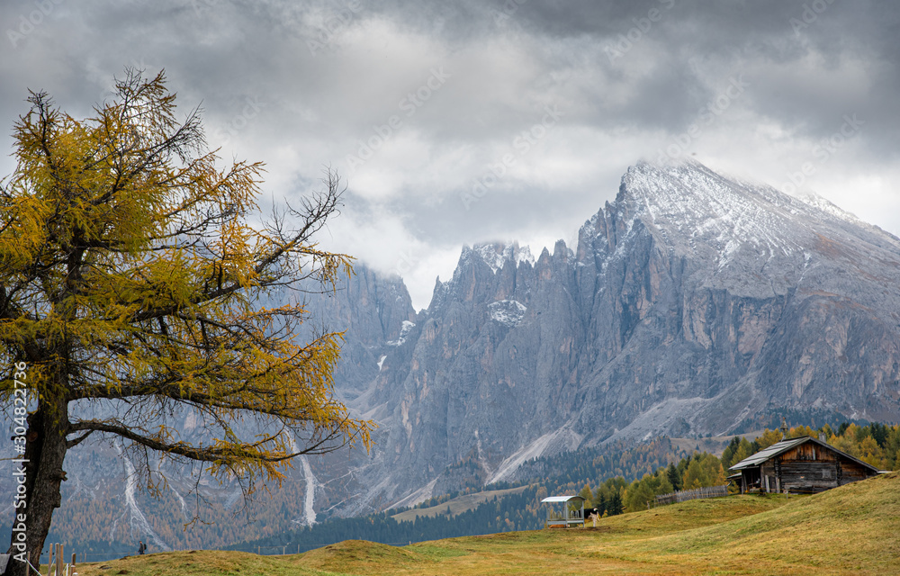 Mountain landscape with Dolomite rocky peak covered with clouds at the at the  Alpe di Siusi valley on the Dolomites, South Tyrol in Italy