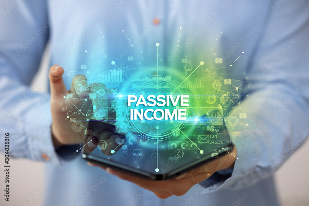 Businessman holding a foldable smartphone with PASSIVE INCOME inscription, new business concept Businessman holding a foldable smartphone with PASSIVE INCOME inscription, new business concept
