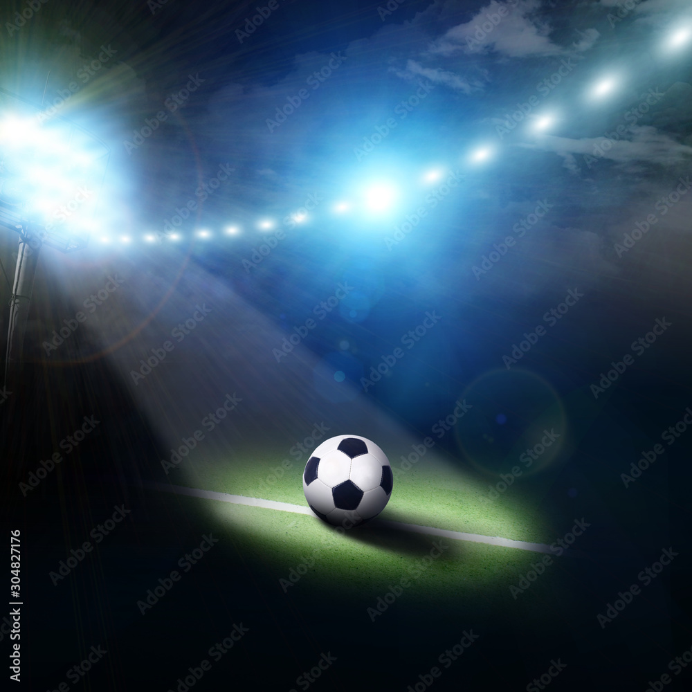Naklejka premium Center of a football field with a ball and stadium lights