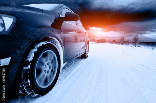 car at winte on the snowly road photo