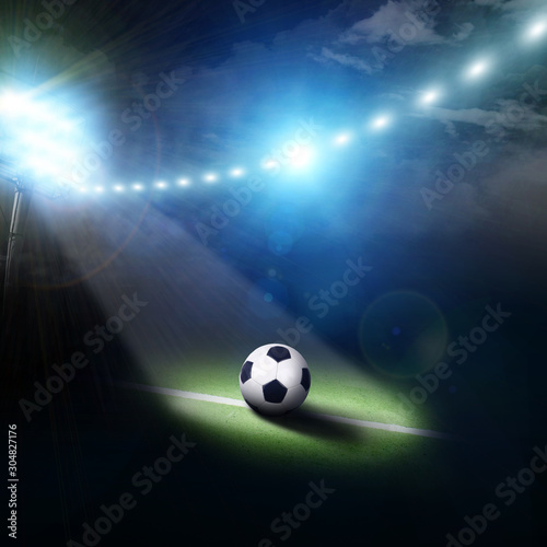 Center of a football field with a ball and stadium lights © Dmitry Perov
