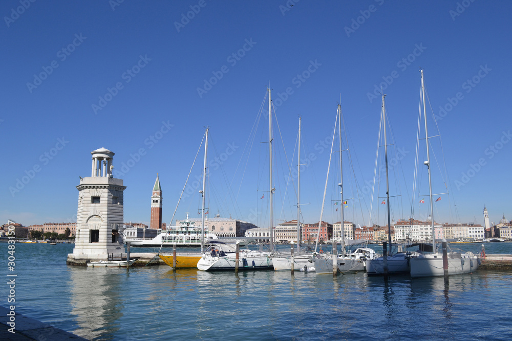 Venetian lagoon. View of the lighthouse of the island of San Giorgio Maggiore. Near the lighthouse there are yachts and boats.