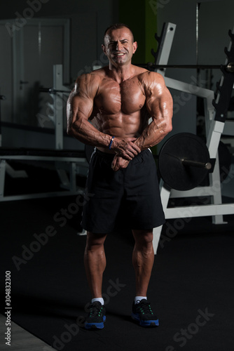 Mature Bodybuilder Standing In The Gym