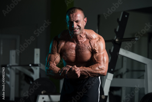 Mature Muscular Man Flexing Muscles In Gym