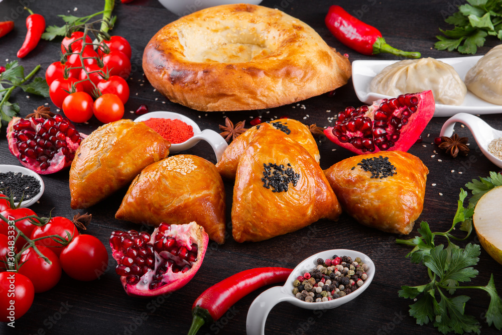 The concept of Eastern asian festive cuisine. Assorted Uzbek food set, pilaf, samsa, lagman, manti, shurpa restaurant concept Eastern arabic new year and Christmas dish from lamb served cookware.