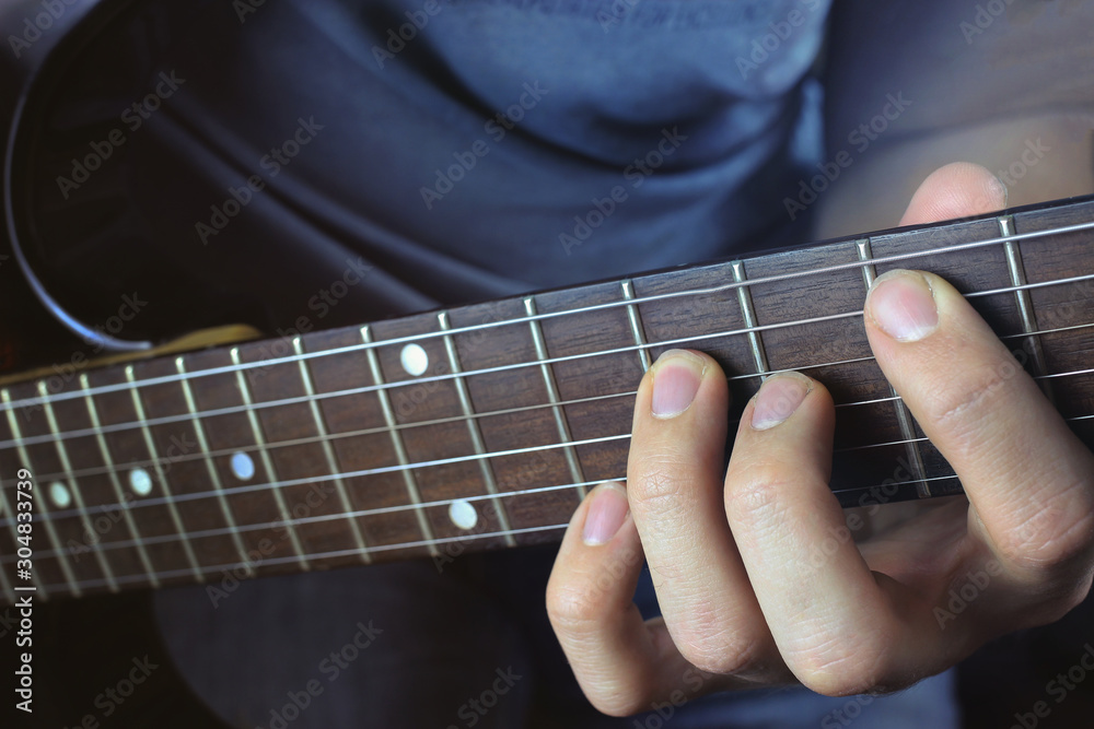 Man playing electric guitar, hand close-up