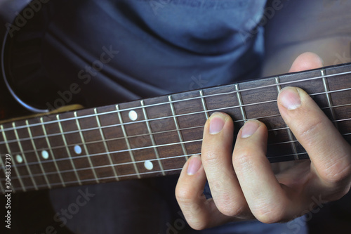 Man playing electric guitar, hand close-up