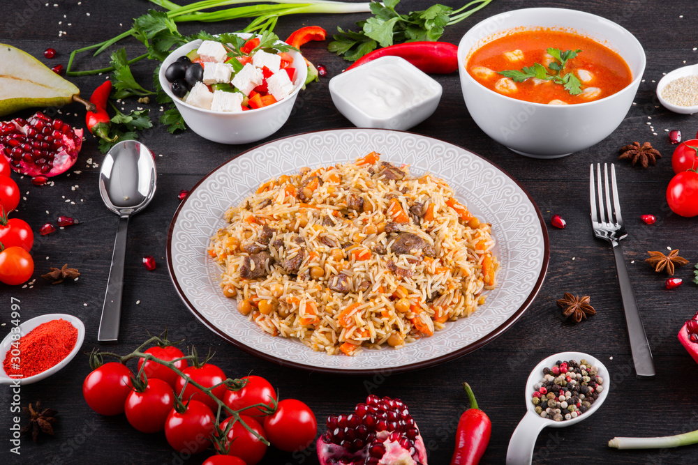 The concept of Eastern asian festive cuisine. Assorted Uzbek food set, pilaf, samsa, lagman, manti, shurpa restaurant concept Eastern arabic new year and Christmas dish from lamb served cookware. The concept of Eastern asian festive cuisine. Assorted Uzbek food set, pilaf, samsa, lagman, manti, shurpa restaurant concept Eastern arabic new year and Christmas dish from lamb served cookware.