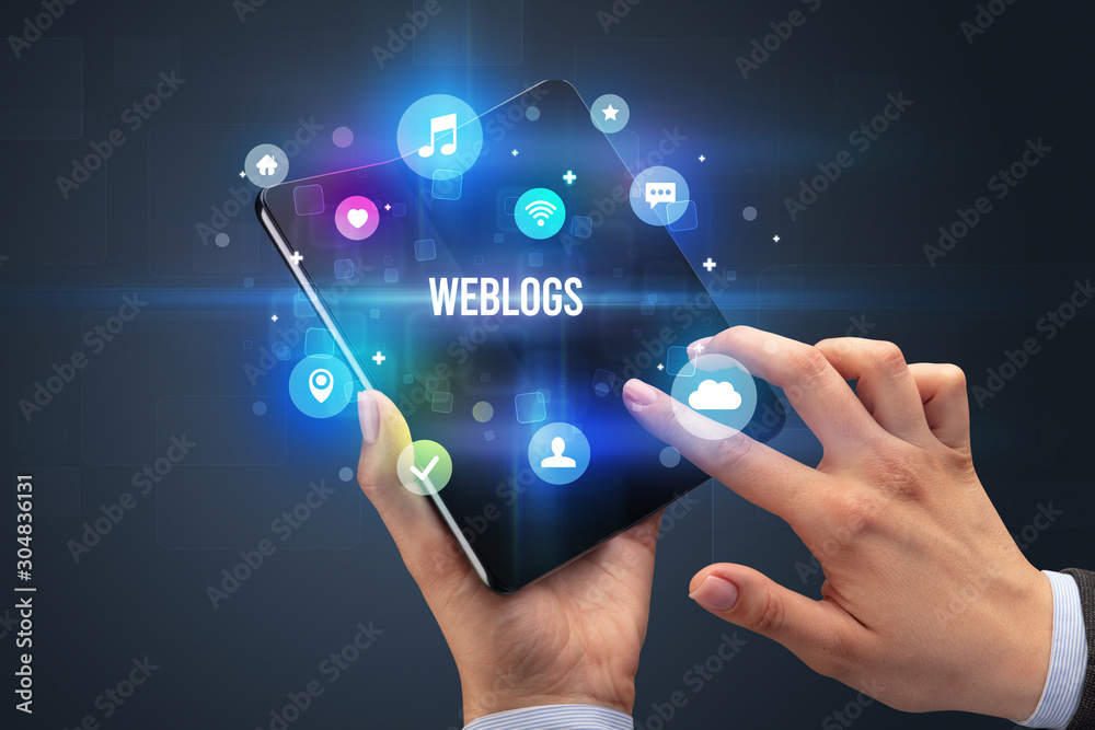 Businessman holding a foldable smartphone with WEBLOGS inscription, social media concept Businessman holding a foldable smartphone with WEBLOGS inscription, social media concept