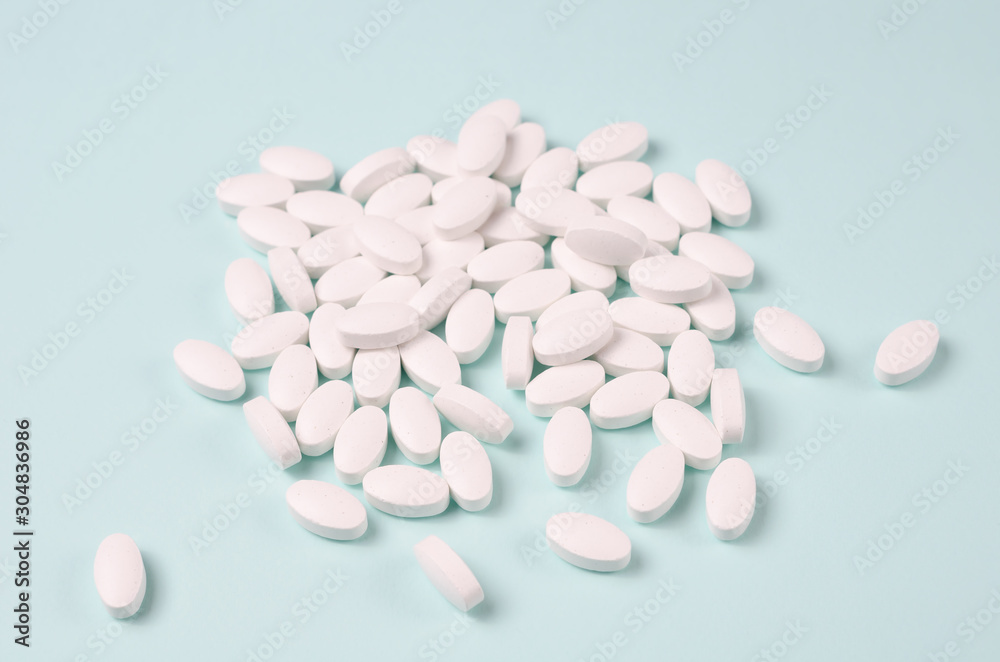White pills over blue background. Selective focus