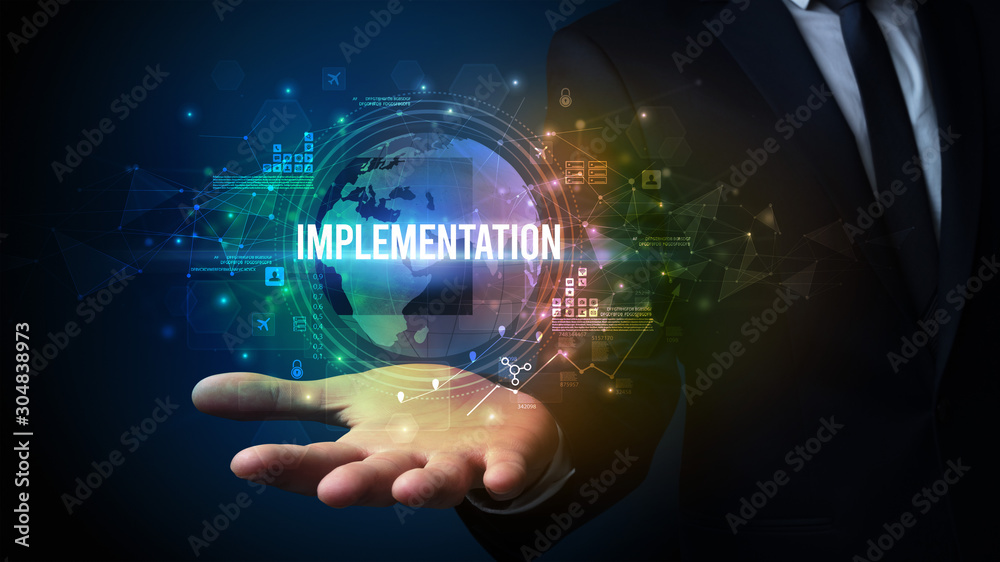 Elegant hand holding IMPLEMENTATION inscription, digital technology concept Elegant hand holding IMPLEMENTATION inscription, digital technology concept