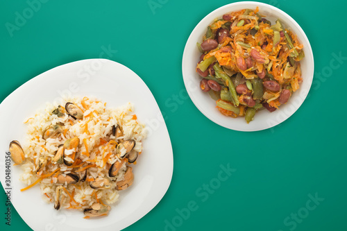 rice with mussels and carrots on awhite plate. rice with mussels and carrots on a colored n background. rice top view. photo