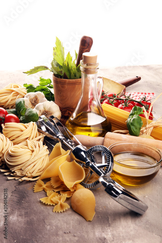 Pasta, vegetables, herbs and spices for Italian food on rustic table