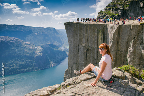 Hiker girl on Prekestulen Mountain, Norway. Girl tourist in the mountains of Norway. Pulpit Rock