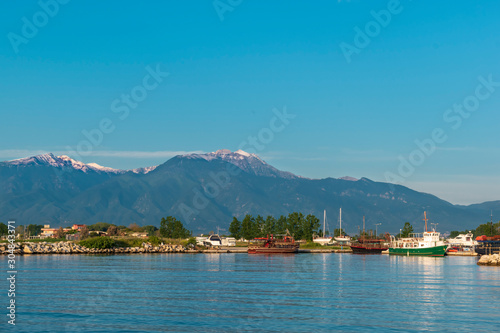 Beautiful bay with fishing boats and a view of Mount Olympus in the background. Katerini Paralia beach, Pieria, Greece.
