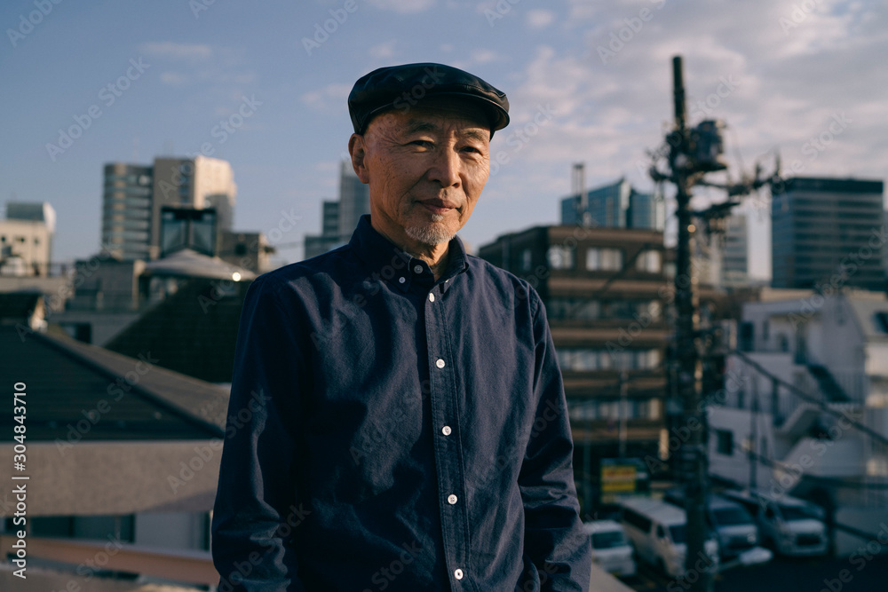 屋上にいる、ハンチング帽を被ったシニア男性のポートレート