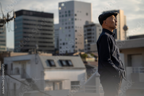 屋上にいる、ハンチング帽を被ったシニア男性のポートレート