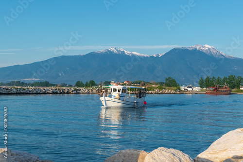 Colorful bay with fishing boats and a view of Mount Olympus in the background. Katerini Paralia beach, Pieria, Greece. photo