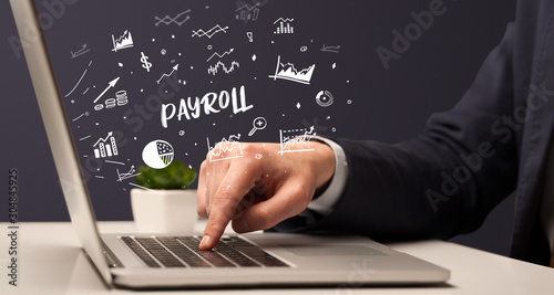 Businessman working on laptop with PAYROLL inscription, modern business concept