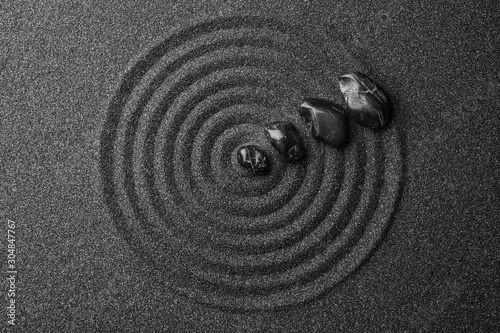 Photography Black sand with stones and beautiful pattern, flat lay