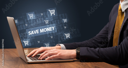 Businessman working on laptop with SAVE MONEY inscription, online shopping concept
