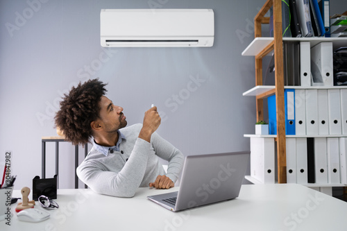 Businessman Operating Air Conditioner photo