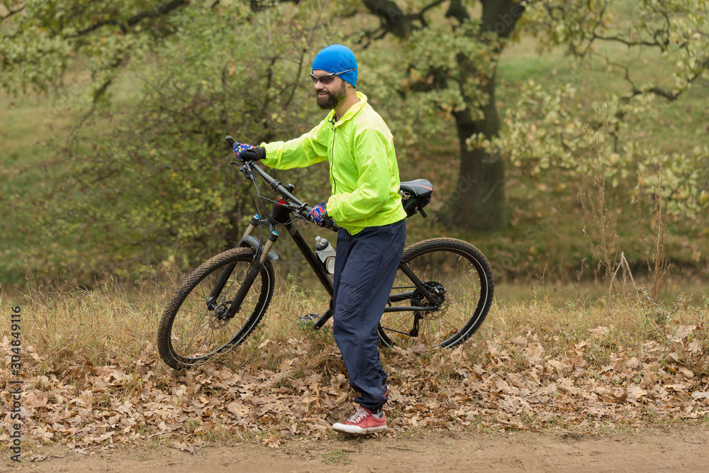 Obraz premium Cyclist in pants and fleece jacket on a modern carbon hardtail bike with an air suspension fork rides off-road. 