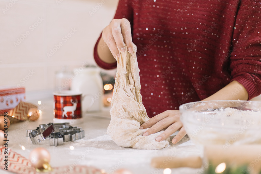 Cropped woman stretching gingerbread dough on countertop