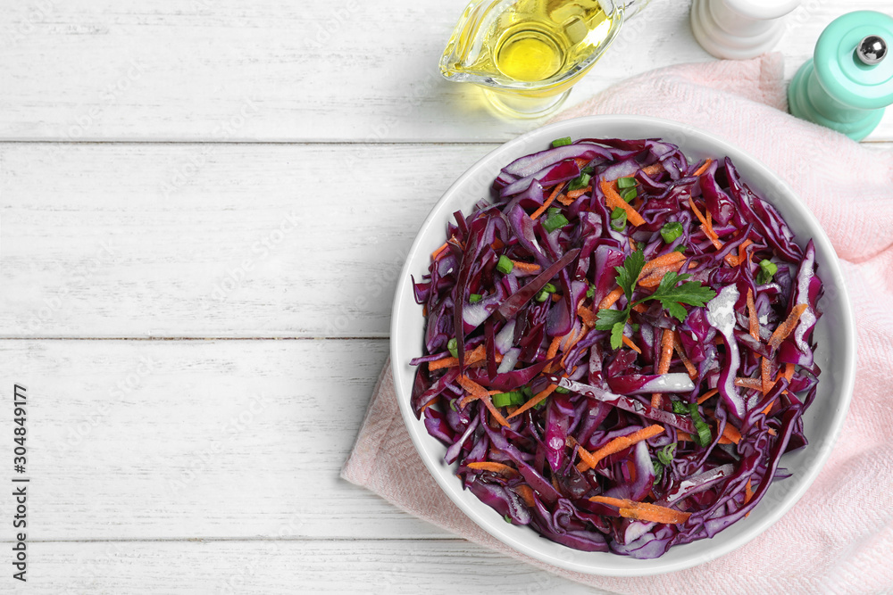 Fresh red cabbage salad served on white wooden table, flat lay. Space for text