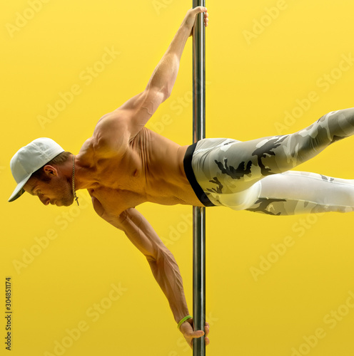 Studio photo of acrobat exercising on pole © Wisky