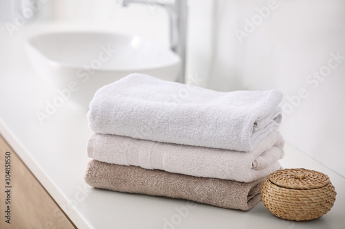 Stack of fresh towels on countertop in bathroom