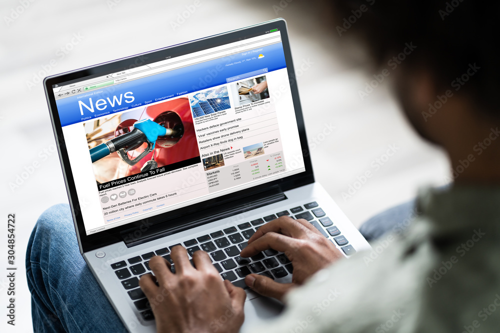 Man Watching Online News On Laptop Man Watching Online News On Laptop